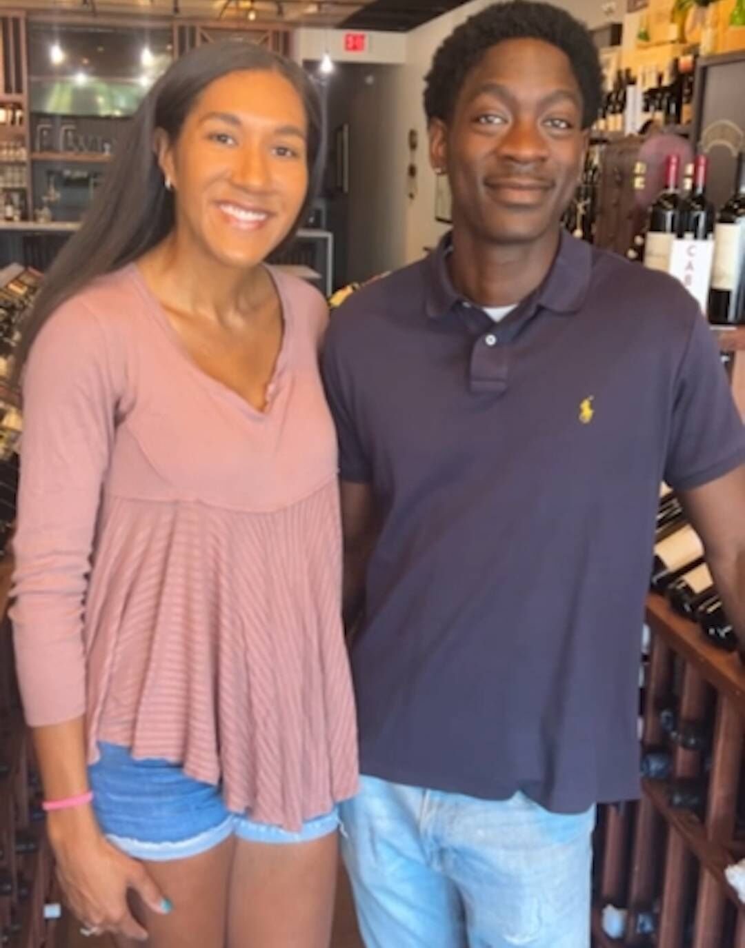 Brittany and Alan Alexander standing together in Ashburn Wine Shop, surrounded by the bottle racks